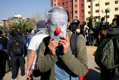 Joven con máscara de anciano en manifestación contra la política tradicional
